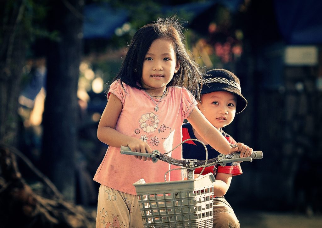 Brother and sister portrait on the bike. 