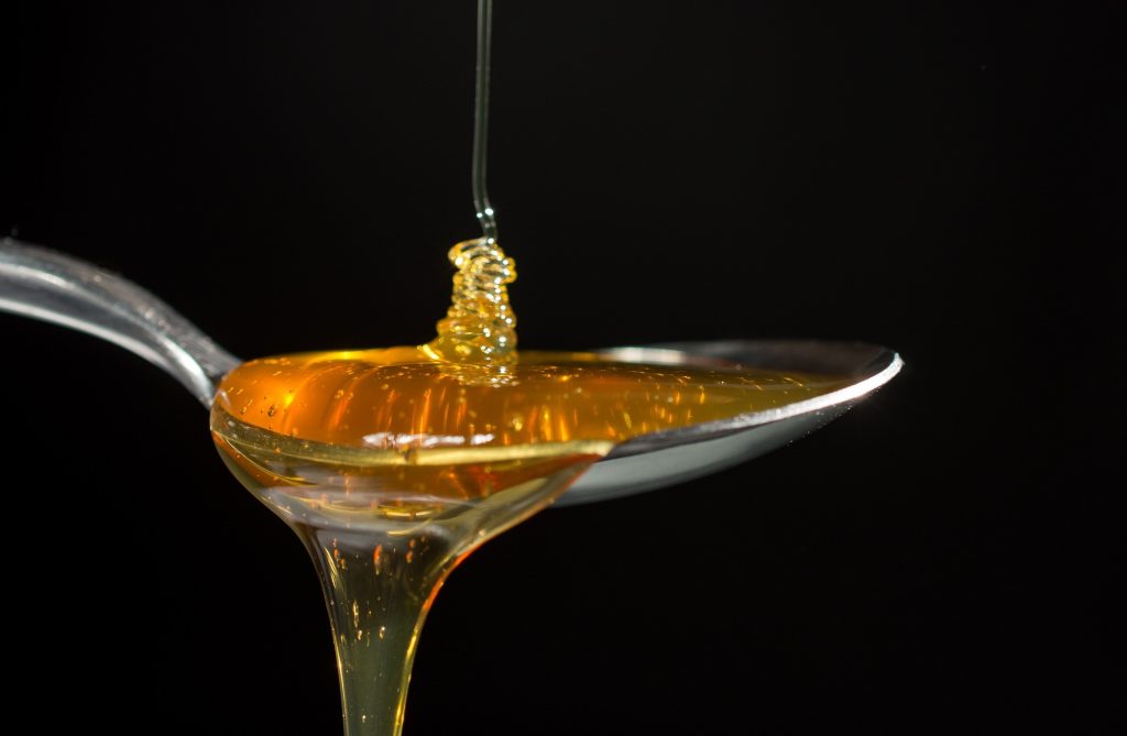 Honey drizzled on a spoon. 