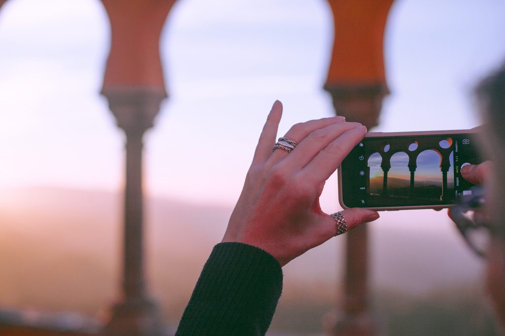 Travel photography, person using a cell phone to capture a scene.